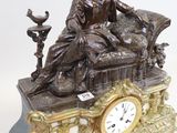 a statue of a woman sitting on a couch with a clock