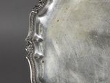 an antique silver plate on a stand on a grey background