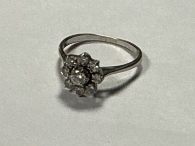 a silver ring with a cluster of diamonds on it
