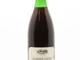 une bouteille de vin posée sur une surface blanche