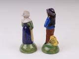 two figurines of people standing next to each other