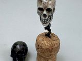 a bottle stopper that has a skull on top of it