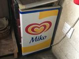 a small refrigerator with a basket on top of it