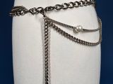 a close up of a mannequin torso with chains and pearls