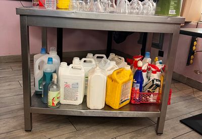 une table en métal sur laquelle se trouvent plusieurs bouteilles de produits d'entretien