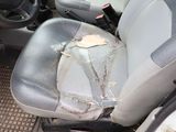 a dirty seat of a car with a broken steering wheel