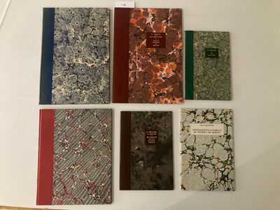 plusieurs livres sont alignés sur une surface blanche