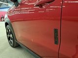 a close up of a red car door with a sticker on it