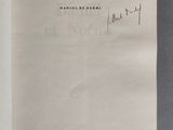 un livre ouvert sur une table, avec un stylo et de l'encre