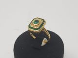 a close up of a ring with a green stone on it