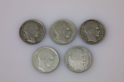 quatre pièces de monnaie britanniques différentes posées sur une surface blanche