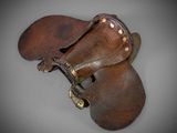 pair of brown leather shoes with studded straps on a gray surface