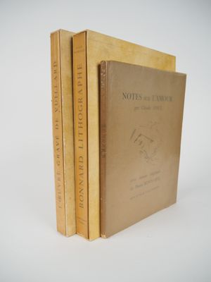 three books are stacked on top of each other on a white surface