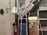 de nombreuses caisses et échelles dans une pièce où se trouve une échelle