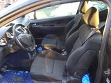the interior of a car with a bottle of water in the passenger seat