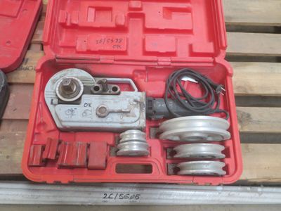 une mallette rouge contenant des outils, posée sur une palette