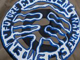 a brown jacket with a blue and white logo on it