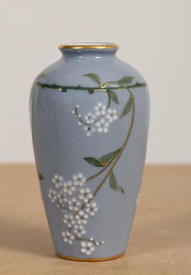 un vase bleu orné de fleurs blanches, posé sur une table