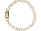 un bracelet de perles blanches avec un fermoir doré sur fond blanc