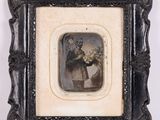 une vieille photo d'une femme tenant un bouquet de fleurs, dans un cadre noir