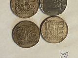 three different coins sitting on top of a piece of paper