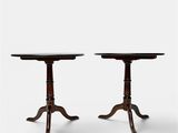 a pair of small tables on pedestals on a white background