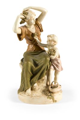 figurine représentant une femme avec un enfant, assise sur un rocher