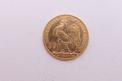gros plan d'une pièce d'or sur une surface blanche