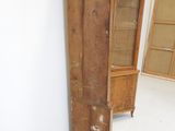 a tall wooden cabinet in a corner of a room