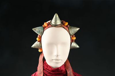 un mannequin portant une écharpe rouge ornée de pointes