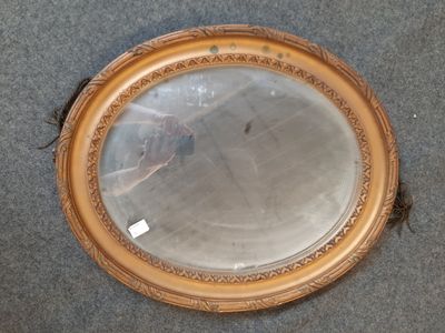 un miroir rond posé par terre, sur lequel est représenté un oiseau