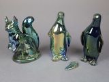 three glass figurines of different shapes and sizes sitting next to each other