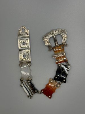 two pieces of silver and glass bracelets on a white surface