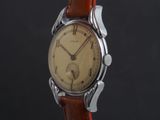 a close up of a wrist watch with a brown leather strap