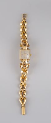 an image of a woman ' s wrist watch with a chain around it