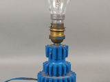une ampoule bleue posée sur un engrenage bleu