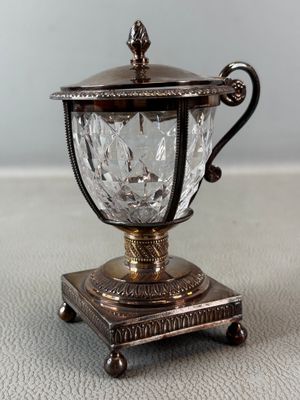 a small silver cup with a handle on a table