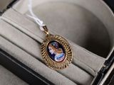 un collier orné d'une image représentant une femme, présenté dans un écrin