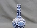 un vase bleu et blanc posé sur un fond gris
