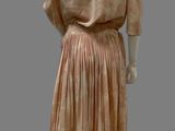 an image of a mannequin wearing a peach dress with pleas