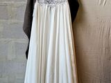 a wedding dress hanging on a hanger against a brick wall