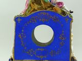 a blue clock with a woman sitting on top of it