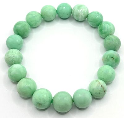 un gros plan sur un bracelet composé de perles de jade vert