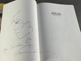 an open book with a drawing of a man ' s face on it