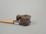 a small pipe with a wooden handle on a gray surface