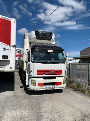 un camion blanc garé à côté d'un camion rouge et blanc