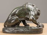 bronze statue of a lion on a rock on a table