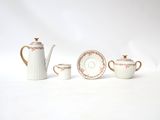 a white tea pot and two cups and a teapot