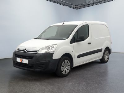 La camionnette blanche est garée dans une grande pièce blanche.