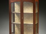 une vitrine ancienne en bois, dotée de portes vitrées et d'étagères